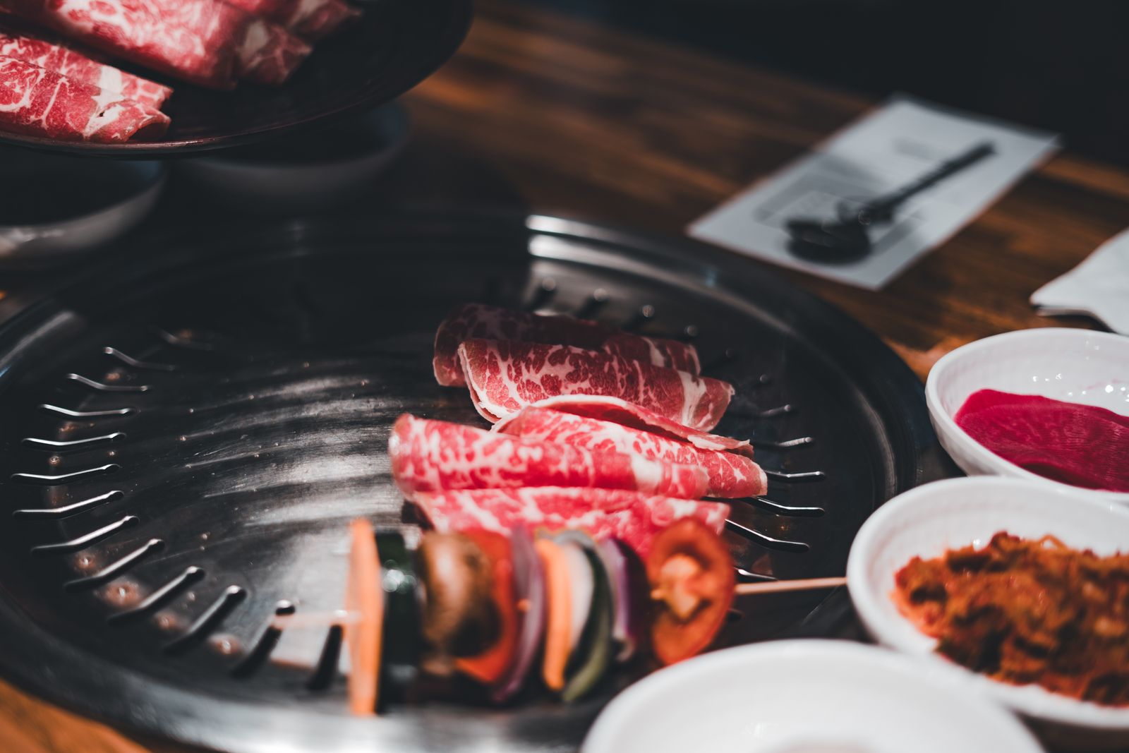 Sliced beef and vegetables cooking on a Korean BBQ grill